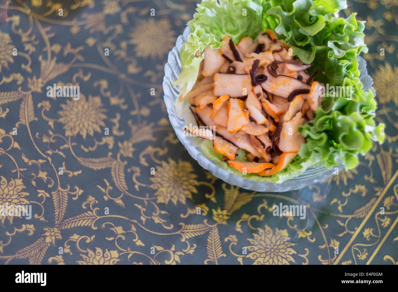 Materie squid sashimi fettine su insalata verde in recipiente di vetro. Foto Stock