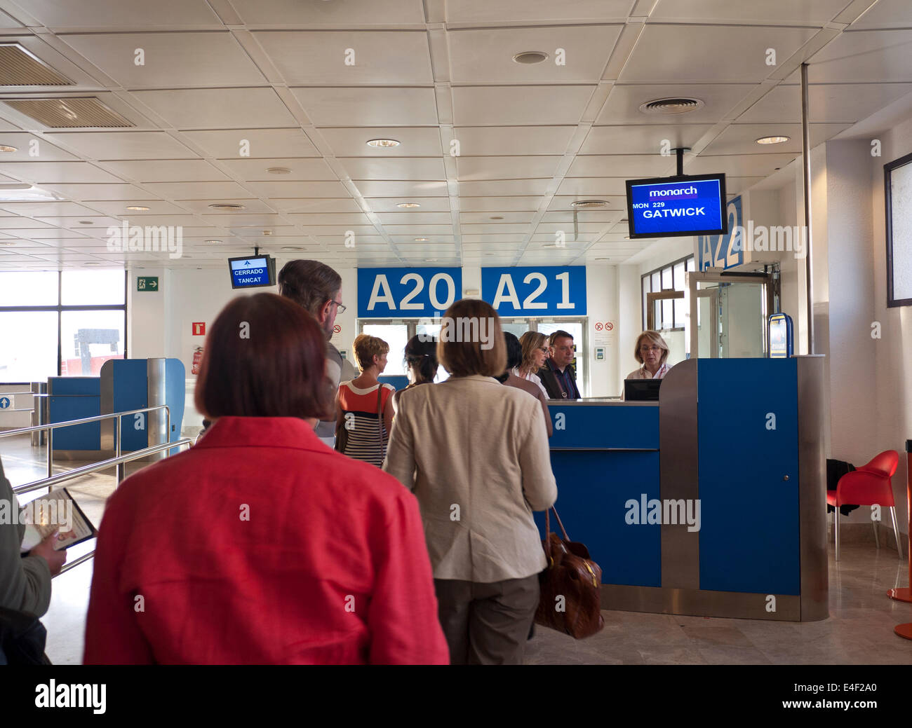 Coda a Monarch boarding gate A20/A21 volo da Palma Mallorca Aeroporto di Londra Gatwick Regno Unito Foto Stock