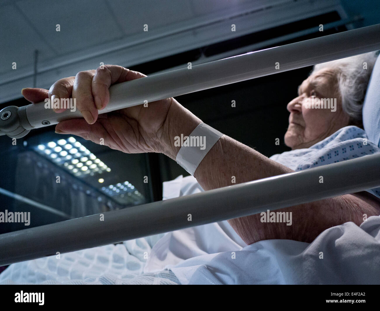 CORONAVIRUS anziani anziani Lady Covid-19 Ospedale preoccupato anziani anziano anziano signora pensionato in letto ospedale di notte mano tenendo letto in primo piano Foto Stock