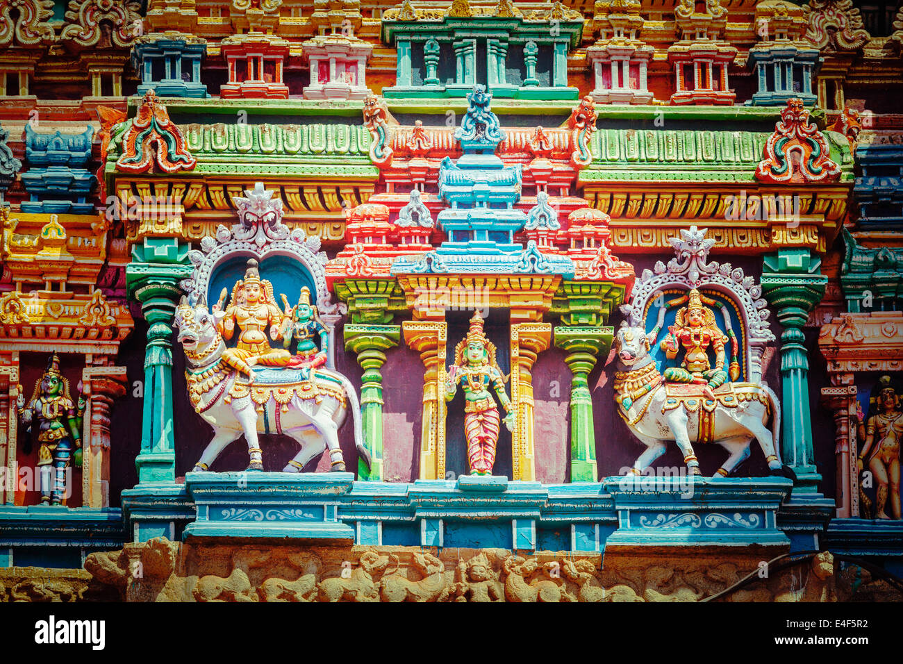 Vintage retrò hipster stile immagine di viaggio di Shiva e Parvati del Bull su immagini. Sculture sul tempio indù gopura (torre). Foto Stock
