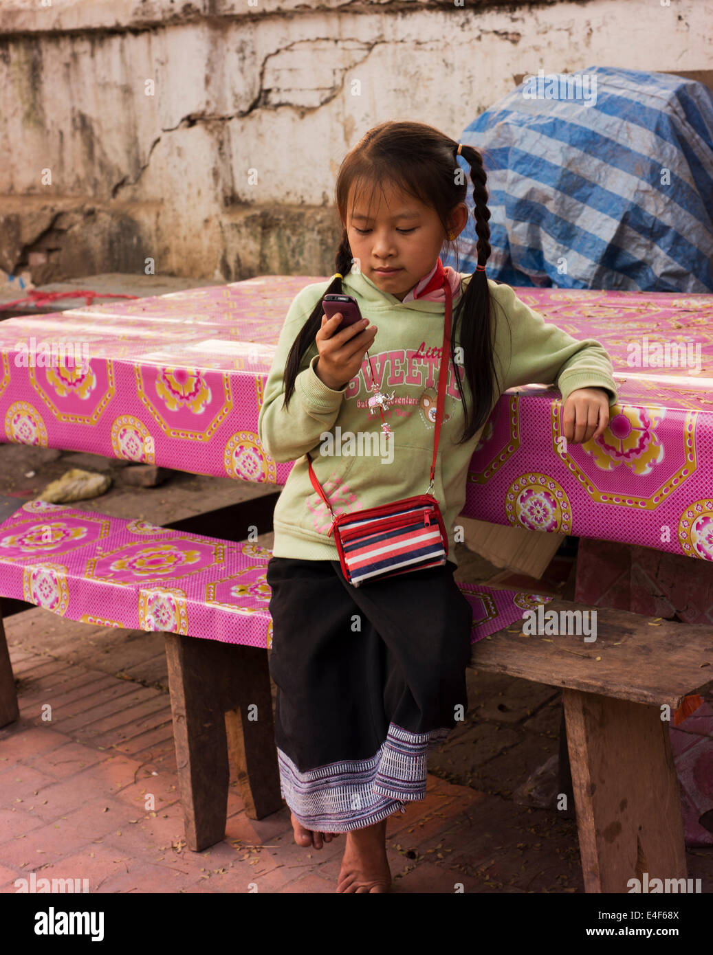 Ragazza giovane con un telefono cellulare a Luang Prabang. Foto Stock