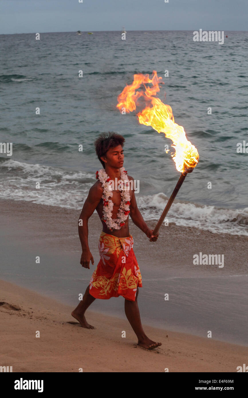 Cliff Diver porta fiamma su Kaanapali Beach verso Black Rock alla luce di torce prima di immergersi durante la mostra Foto Stock