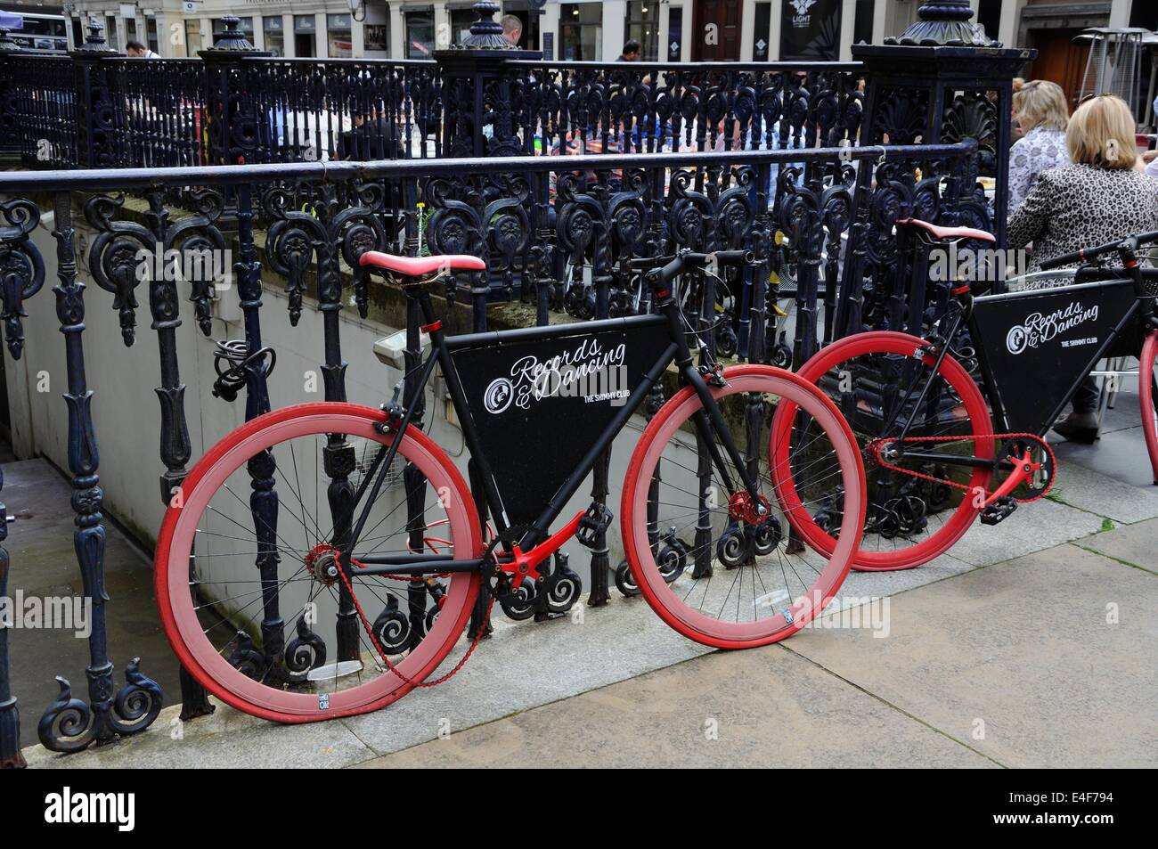 Biciclette con pneumatici rossi per la pubblicità delle Shimmy night club di Glasgow city centre Foto Stock