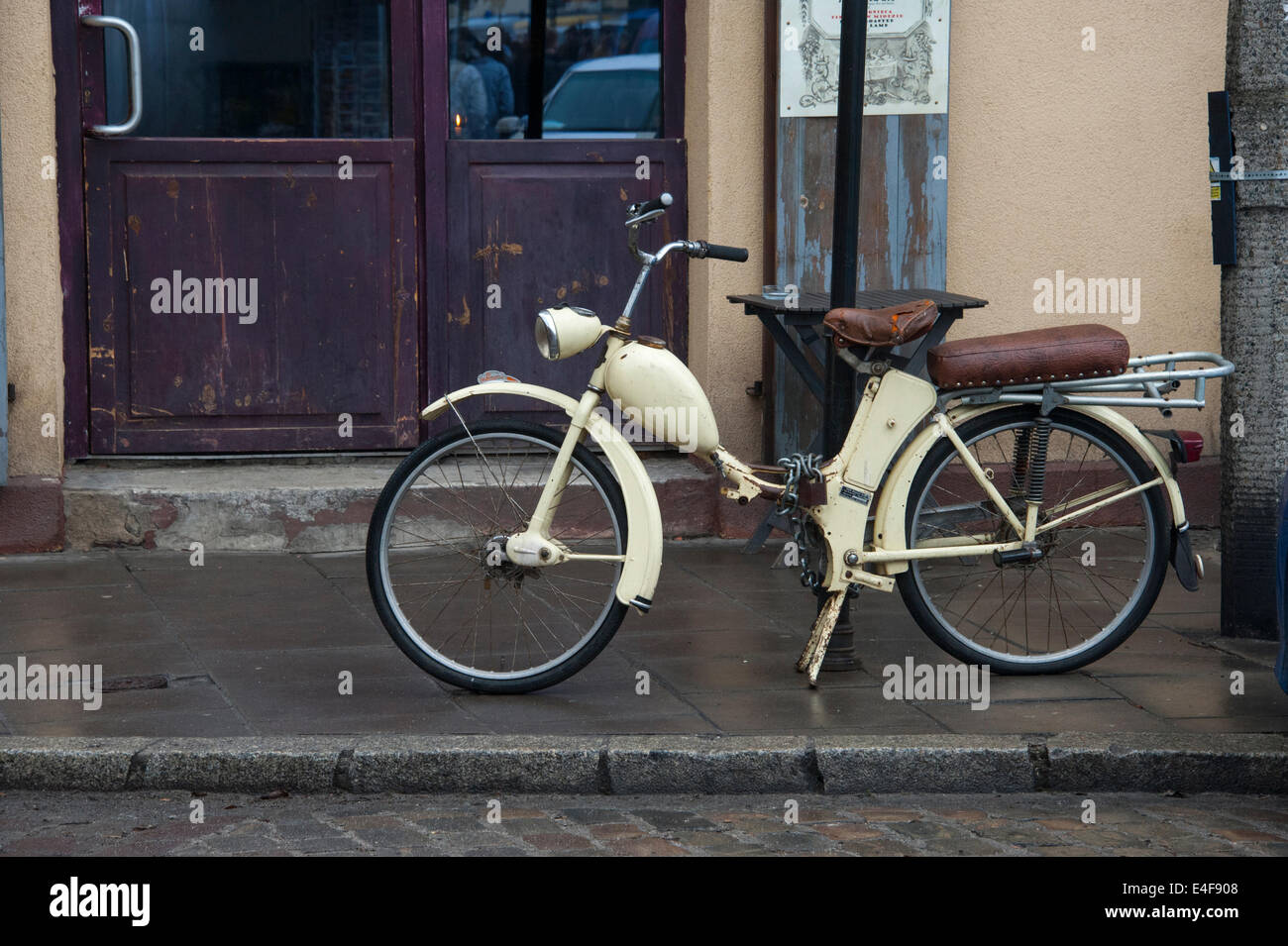 Un vecchio ciclomotore concatenati a un post su una strada di Cracovia. Foto Stock