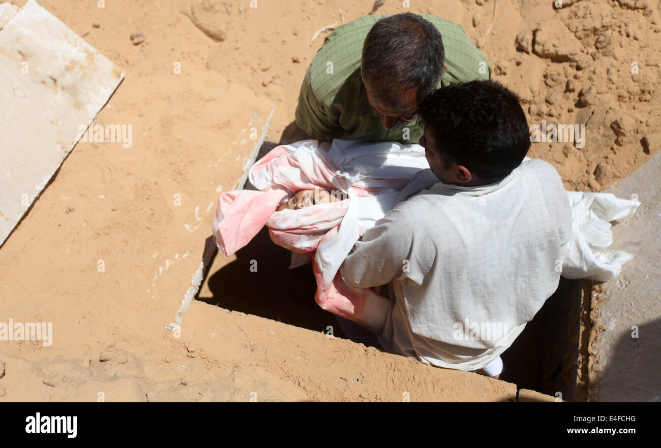 La striscia di Gaza e la striscia di Gaza, Territori palestinesi. 10 Luglio, 2014. Palestinesi burry lutto il corpo del cinque-anno-vecchio ragazzo Abdallah Abu Ghazal durante una cerimonia funebre nel nord della Striscia di Gaza città di Beit Lahiya sulla luglio 10, 2014 dopo che egli è stato ucciso in un attacco aereo israeliano. Almeno cinque bambini palestinesi sono stati tra 22 persone uccise in incursioni aeree israeliane su Gaza presto oggi, i medici hanno detto, con la maggior parte del sangue nella città meridionale di Khan Yunis. Credito: Majdi Fathi/NurPhoto/ZUMA filo/Alamy Live News Foto Stock