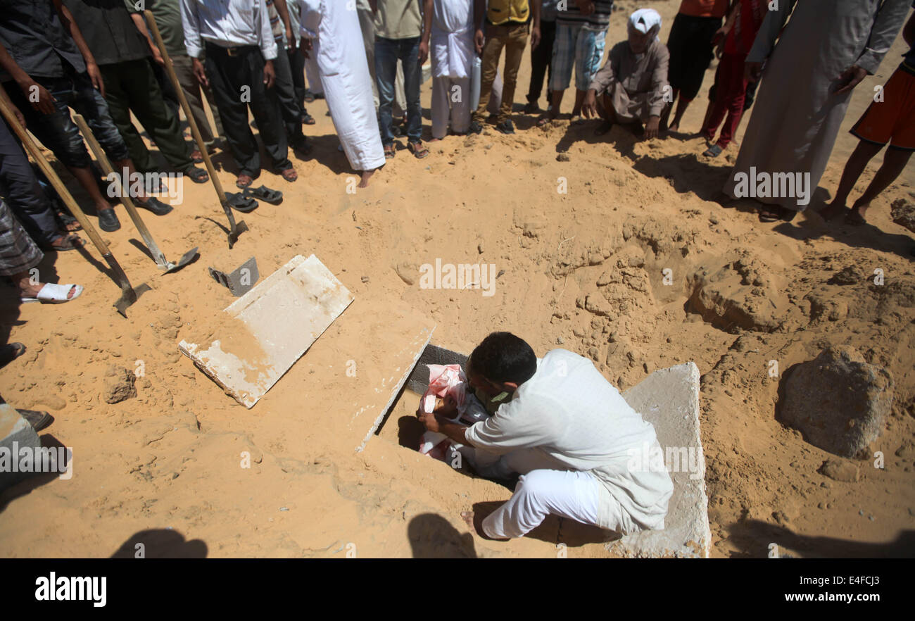 La striscia di Gaza e la striscia di Gaza, Territori palestinesi. 10 Luglio, 2014. Palestinesi burry lutto il corpo del cinque-anno-vecchio ragazzo Abdallah Abu Ghazal durante una cerimonia funebre nel nord della Striscia di Gaza città di Beit Lahiya sulla luglio 10, 2014 dopo che egli è stato ucciso in un attacco aereo israeliano. Almeno cinque bambini palestinesi sono stati tra 22 persone uccise in incursioni aeree israeliane su Gaza presto oggi, i medici hanno detto, con la maggior parte del sangue nella città meridionale di Khan Yunis. Credito: Majdi Fathi/NurPhoto/ZUMA filo/Alamy Live News Foto Stock