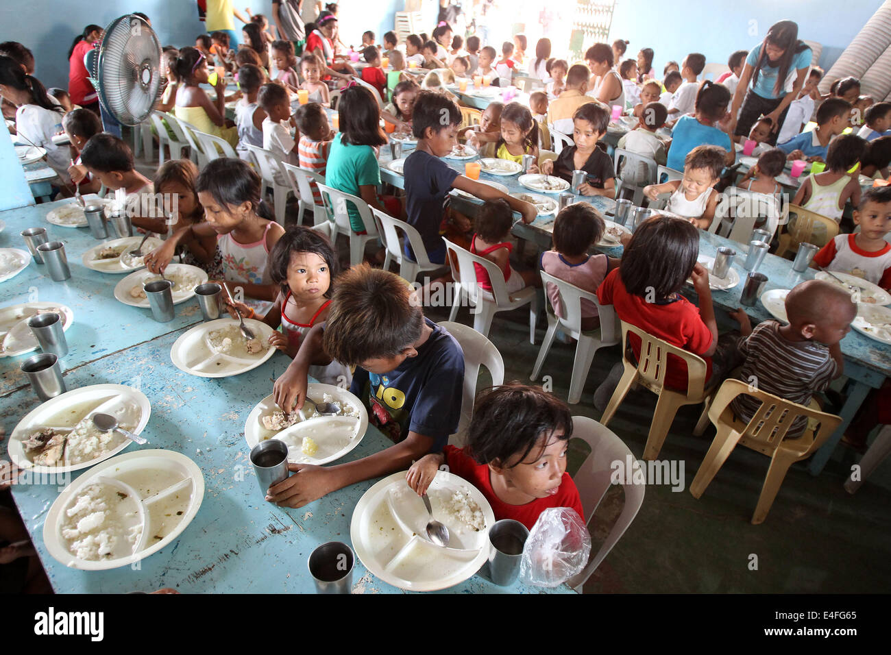 Manila, Filippine. 10 Luglio, 2014. I bambini mangiano durante un'organizzazione non governativa Programma di alimentazione in corrispondenza di una delle baraccopoli di Manila, Filippine, 10 luglio 2014. La popolazione delle Filippine ha una costante crescita del 1,89 percento, classifica come il dodicesimo paese più popoloso del mondo, con 100,617,630 nel 2014. © Rouelle Umali/Xinhua/Alamy Live News Foto Stock