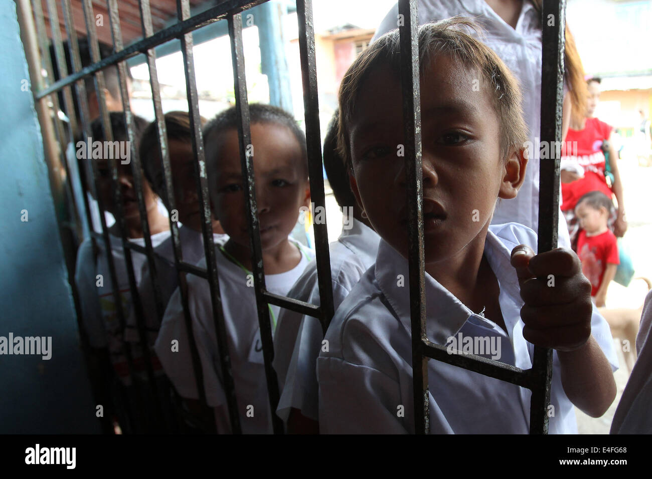 Manila, Filippine. 10 Luglio, 2014. Bambini line up per alimentare durante un'organizzazione non governativa Programma di alimentazione in corrispondenza di una delle baraccopoli di Manila, Filippine, 10 luglio 2014. La popolazione delle Filippine ha una costante crescita del 1,89 percento, classifica come il dodicesimo paese più popoloso del mondo, con 100,617,630 nel 2014. © Rouelle Umali/Xinhua/Alamy Live News Foto Stock