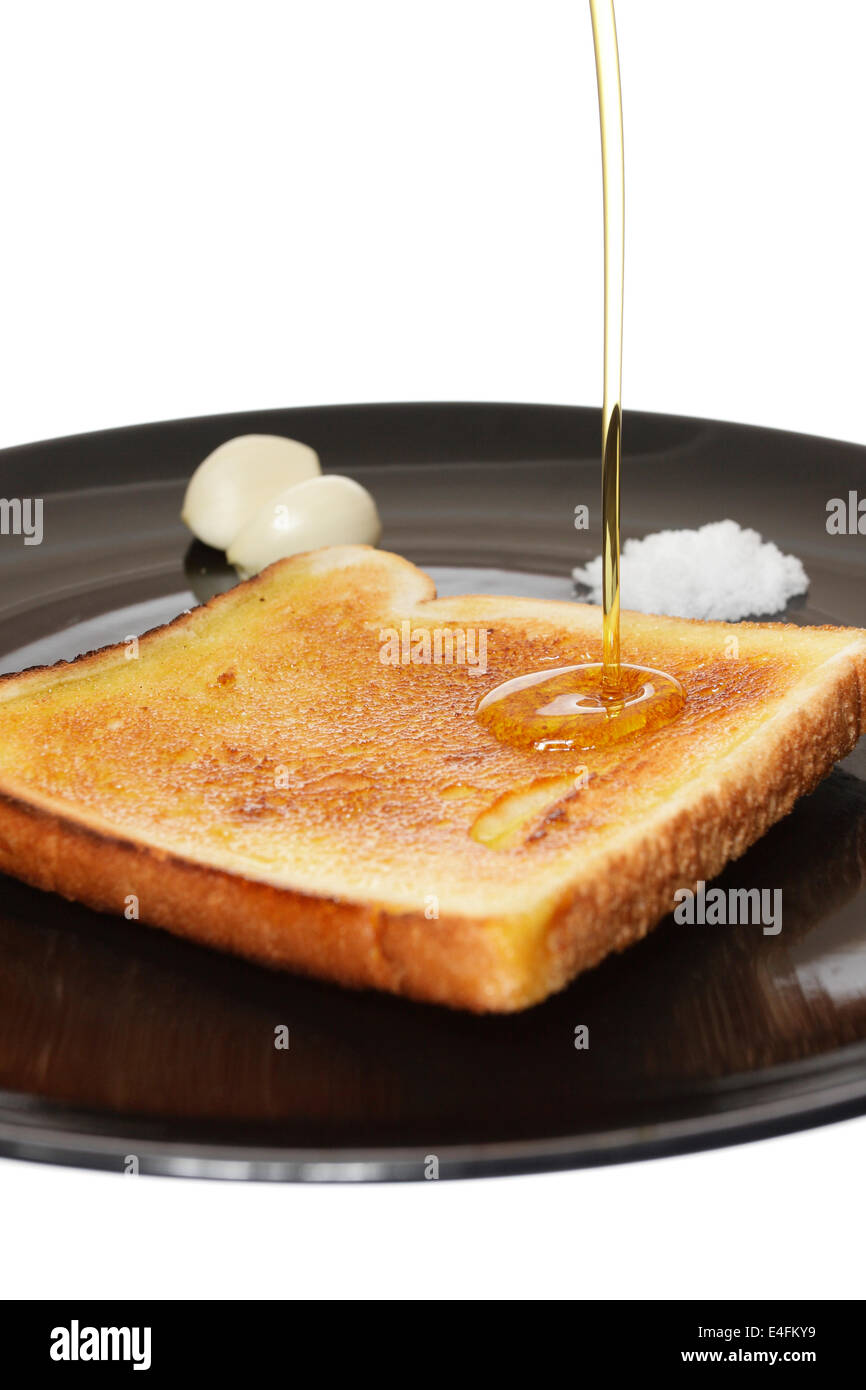 Dieta mediterranea della prima colazione con toast di pane, aglio, sale e olio di oliva. Foto Stock