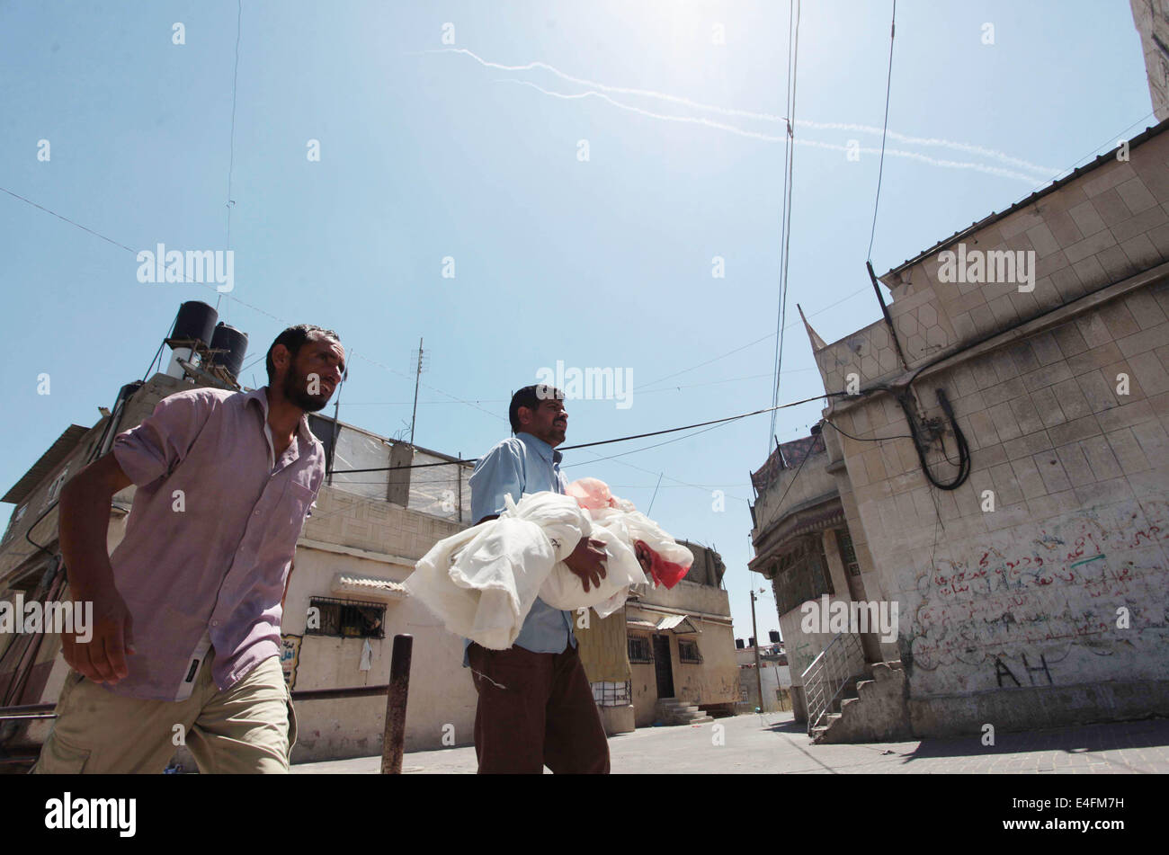 Beit Lahiya, Striscia di Gaza, Territori palestinesi. 10 Luglio, 2014. Un palestinese relativo porta il corpo di cinque-anno-vecchio ragazzo Abdallah Abu Ghazal durante il suo funerale come un razzo lanciato dalla striscia costiera in Israele da parte di militanti nel nord della Striscia di Gaza città di Beit Lahiya sulla luglio 10, 2014 dopo che egli è stato ucciso in un attacco aereo israeliano. Almeno cinque bambini palestinesi sono stati tra 22 persone uccise in incursioni aeree israeliane su Gaza presto oggi, i medici hanno detto, con la maggior parte del sangue nella città meridionale di Khan Yunis Credito: Ashraf Amra/immagini APA/ZUMA filo/Alamy Live News Foto Stock