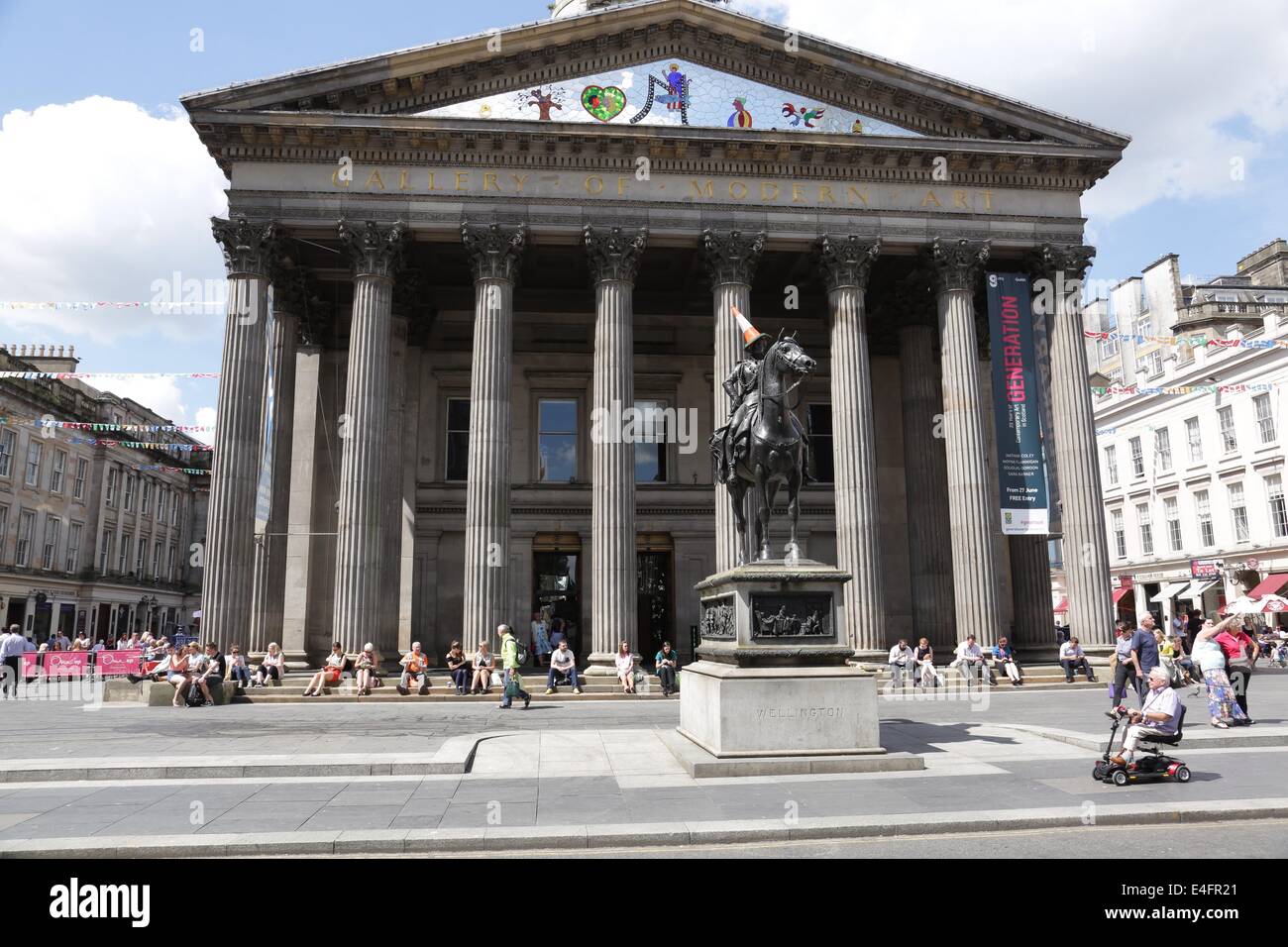 Royal Exchange Square / Queen Street, Glasgow, Scozia, Regno Unito, 10 luglio 2014. Glasswegiani, impiegati e visitatori della città sfruttando al massimo il clima asciutto, caldo e luminoso variabile fuori dalla Galleria d'Arte moderna Foto Stock