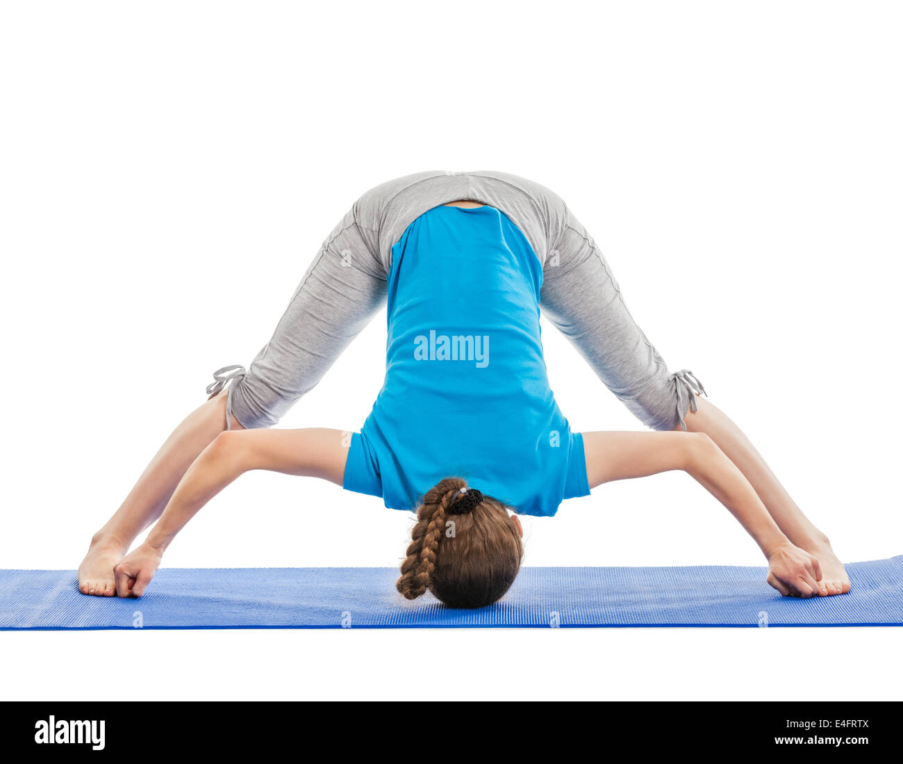 Yoga - giovane bella donna slanciata istruttore yoga facendo ampio zampe avanti permanente piegare D (Prasarita Padottanasana D) asana Foto Stock