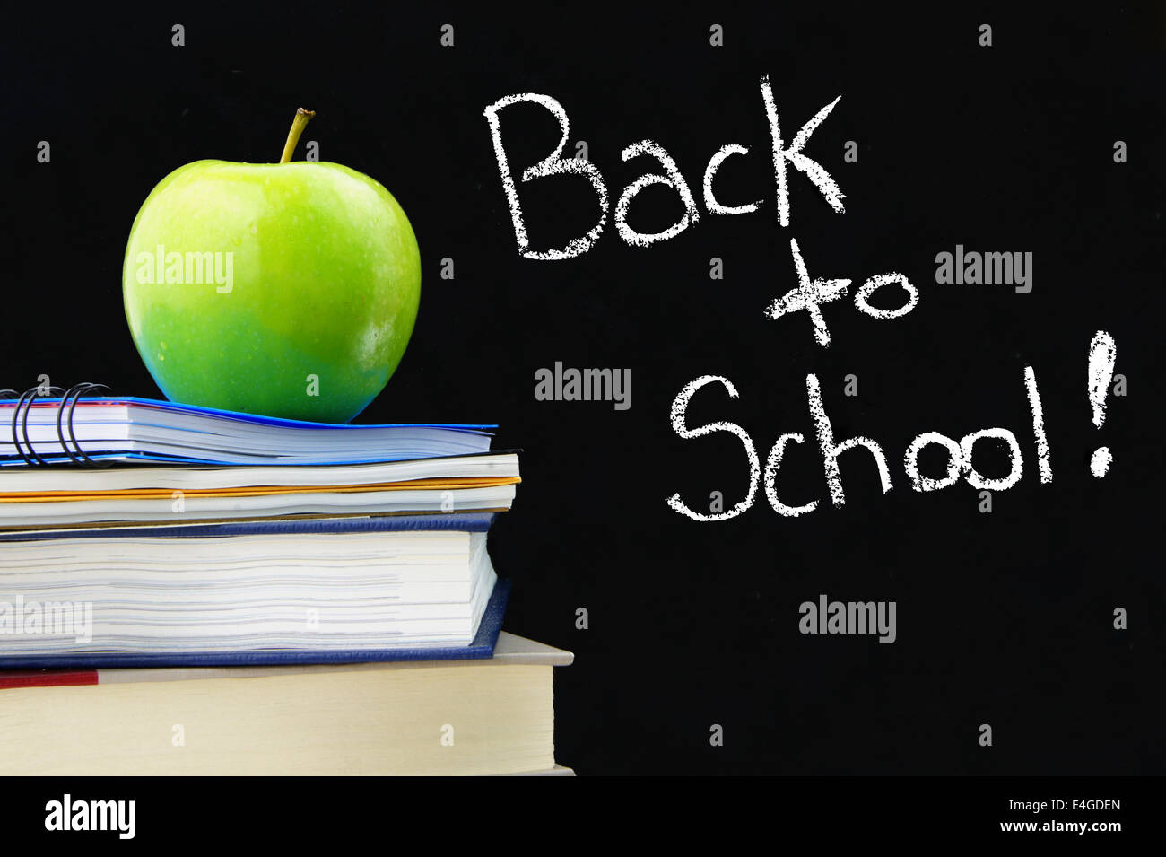 Si torna a scuola scritto su una lavagna con libri e Apple nella parte anteriore Foto Stock