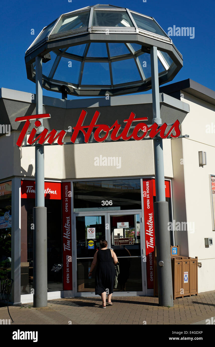 Donna inserendo un Tim Hortons caffetteria e ristorante in Vancouver, BC, Canada Foto Stock