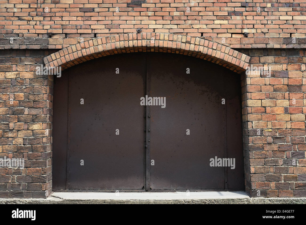 Metallo arrugginito porta nel vecchio muro di mattoni Foto Stock