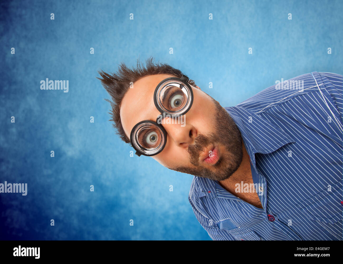 Ragazzo con espressioni di sorpresa e occhiali su sfondo bianco Foto Stock