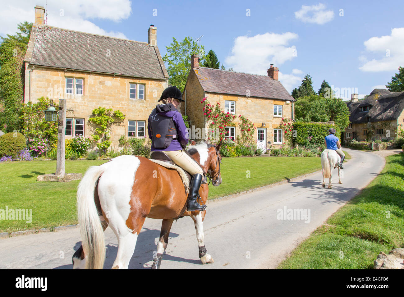 Equitazione nel villaggio Costwold di Stanton, Gloucestershire, England, Regno Unito Foto Stock