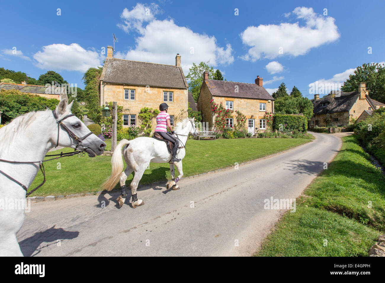 Equitazione nel villaggio Costwold di Stanton, Gloucestershire, England, Regno Unito Foto Stock