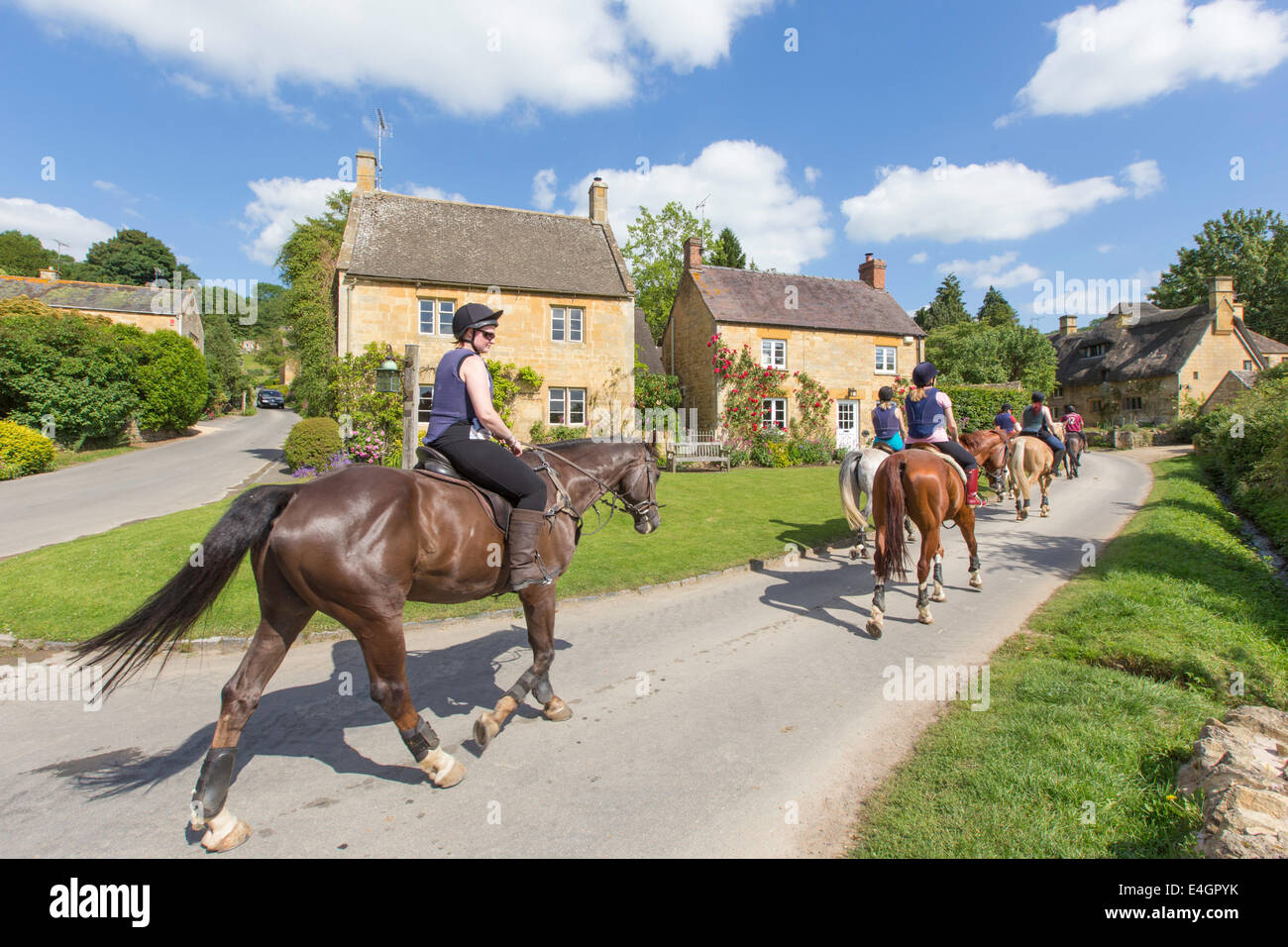 Equitazione nel villaggio Costwold di Stanton, Gloucestershire, England, Regno Unito Foto Stock