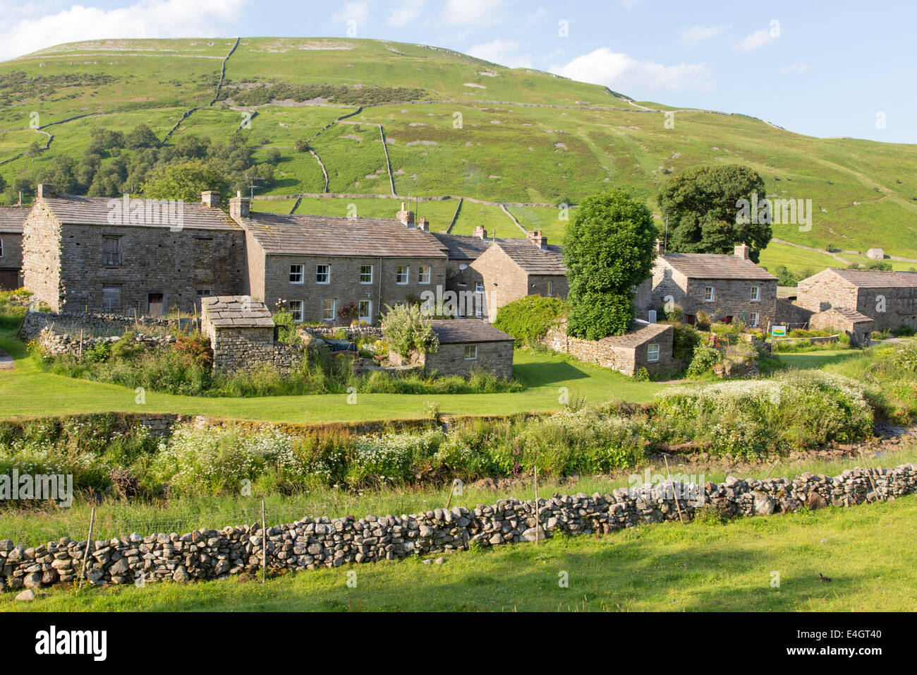 Luce della Sera sopra il villaggio di Thwaite, Swaledale superiore, Yorkshire Dales National Park, England, Regno Unito Foto Stock