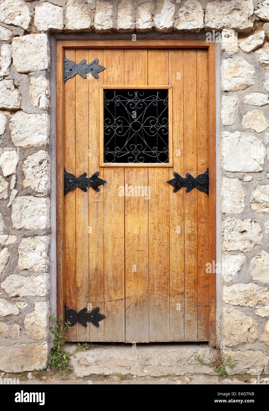 Vecchia porta di legno nel muro di pietra Foto stock - Alamy
