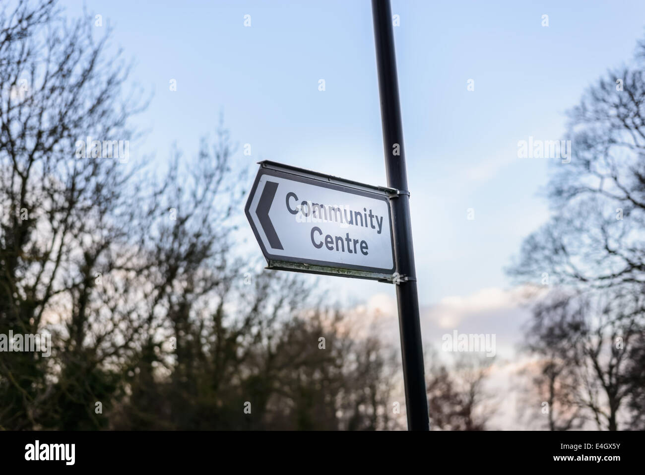 British " Comunità centro centro" cartello stradale con freccia, elevato su un post su una strada. Foto Stock