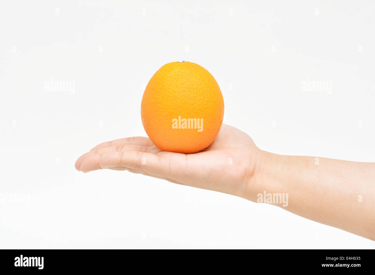 Offrendo uno arancione sul palm con la mano destra. Foto Stock