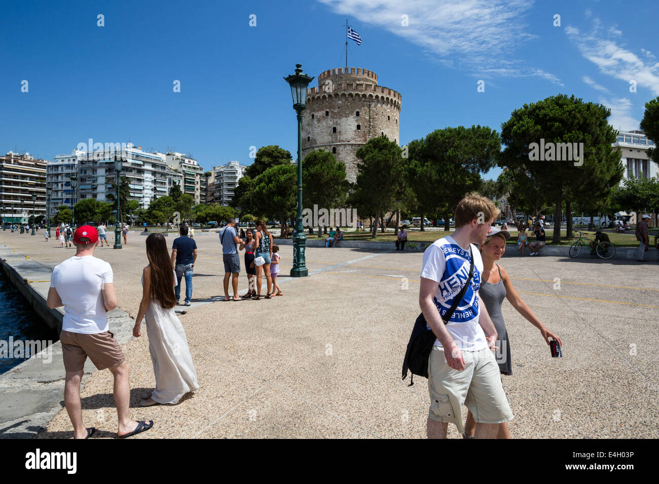 Salonicco, Grecia. 11 luglio 2014. I turisti a piedi nella parte anteriore del distintivo della città, la Torre Bianca, sul lungomare di Salonicco, Grecia. L'Associazione del turismo greco imprese (SETE) ha aumentato la sua stima per gli arrivi turistici internazionali nel 2014 a 19 milioni di euro da 18,5 milioni dello scorso anno. Salonicco, Grecia sulla luglio 11, 2014. Credito: Konstantinos Tsakalidis/Alamy Live News Foto Stock