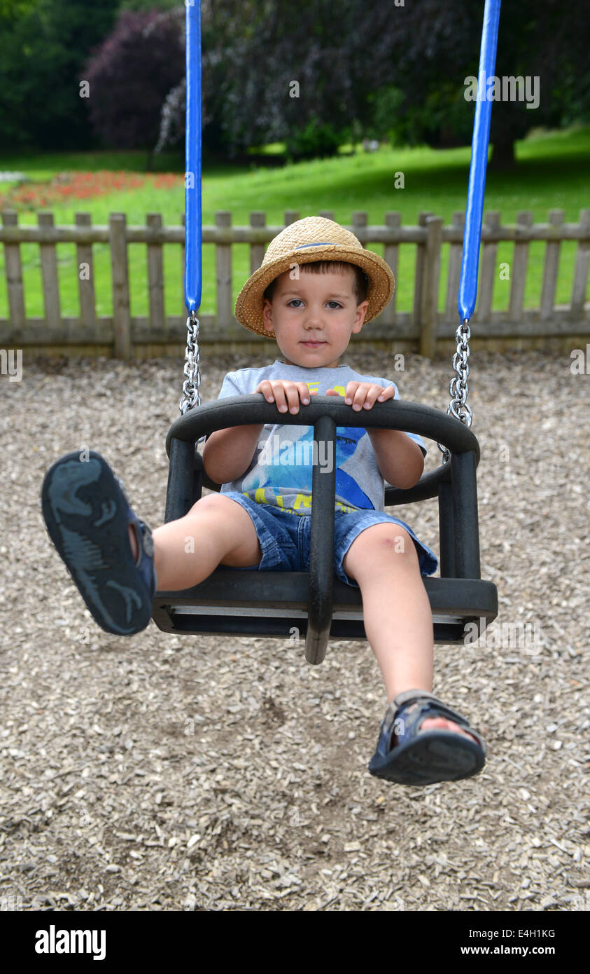 Bambino su un campo giochi per bambini swing Regno Unito Foto Stock