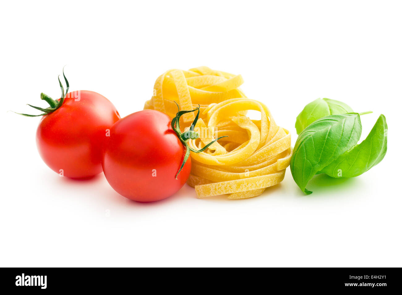 La pasta italiana Le tagliatelle, i pomodori e le foglie di basilico Foto Stock