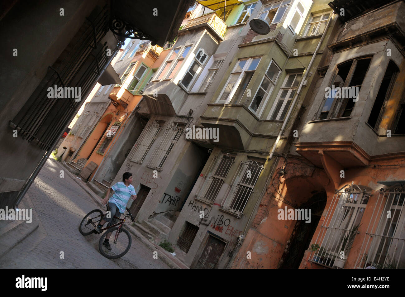 Un giovane ragazzo turco su una bicicletta invita un amico su una vecchia strada del Fener/area di Balat dal Golden Horn. Foto Stock