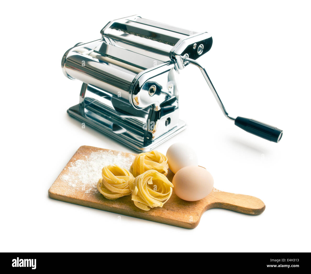 Tagliatelle,uova e macchina per la pasta su sfondo bianco Foto Stock