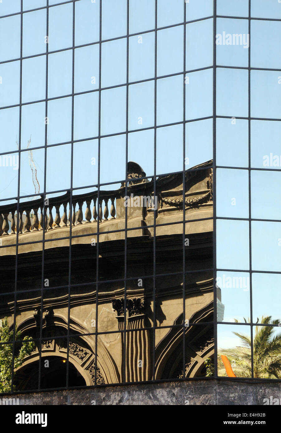 Parte di un classico edificio coloniale si riflette in un moderno edificio nella Plaza de Armas. Santiago del Cile Foto Stock