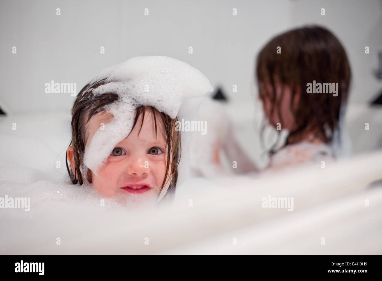 Le ragazze a giocare in una vasca da bagno con bolle Foto Stock