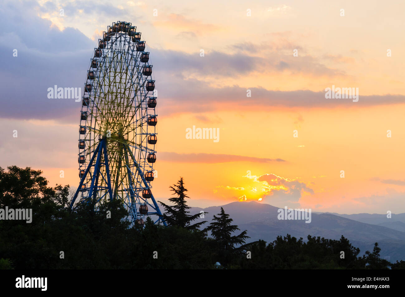 Ruota panoramica Ferris al tramonto. Mtatsminda Amusement Park, Tbilisi, Georgia Foto Stock