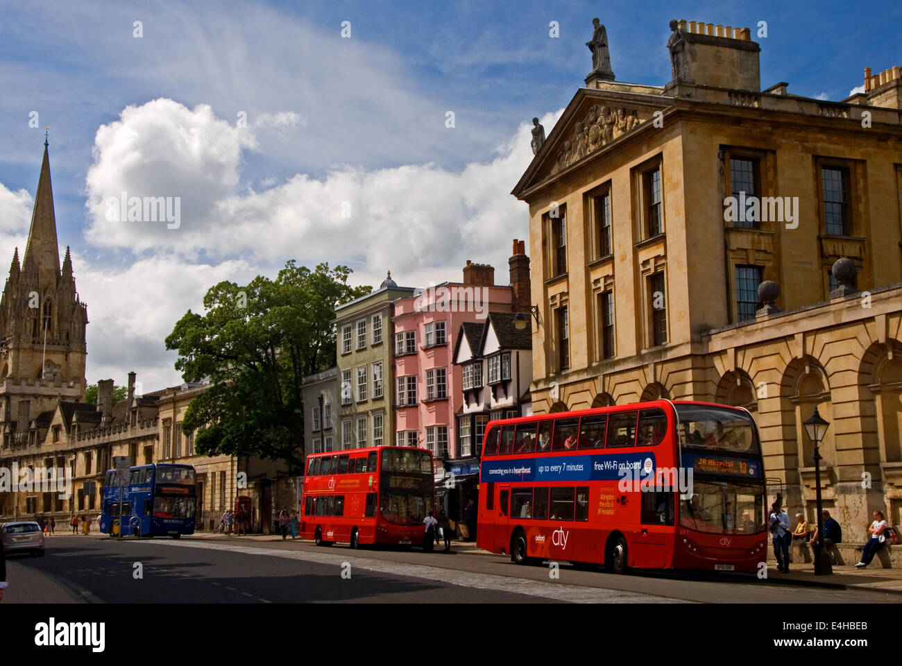 High Street, o 'Alta' in Oxford con un trio di autobus in attesa a varie fermate di autobus. Foto Stock