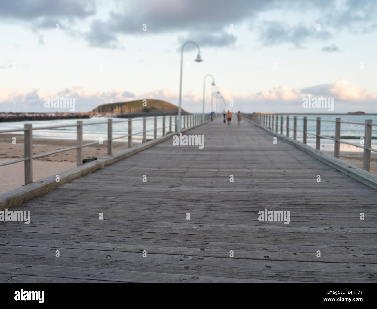 Ponte di legno che si estende verso l'oceano Foto Stock