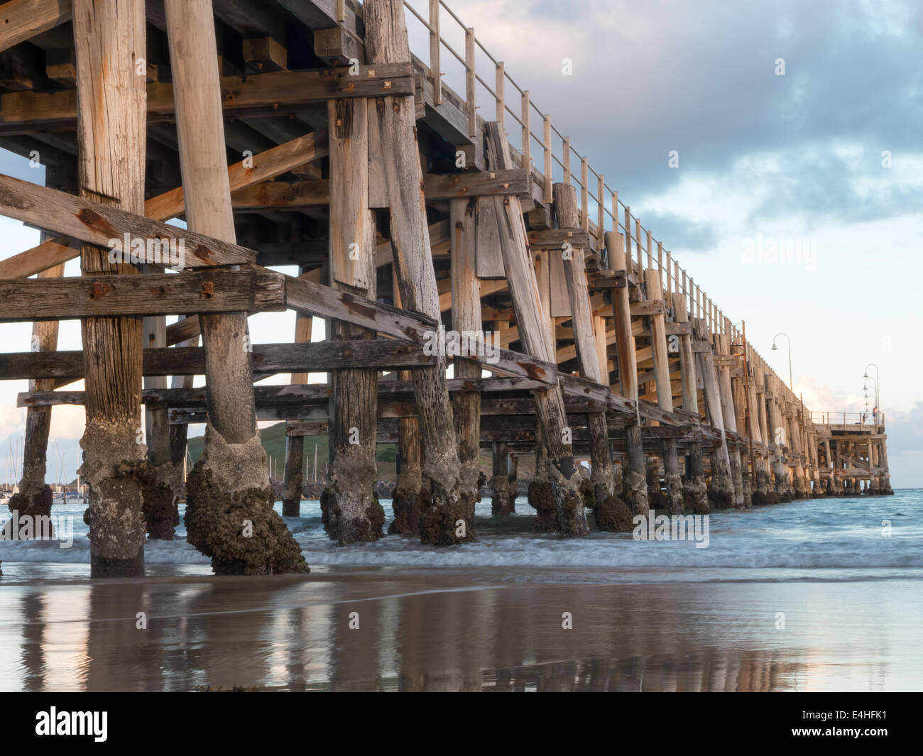 Ponte di legno che si estende verso l'oceano Foto Stock