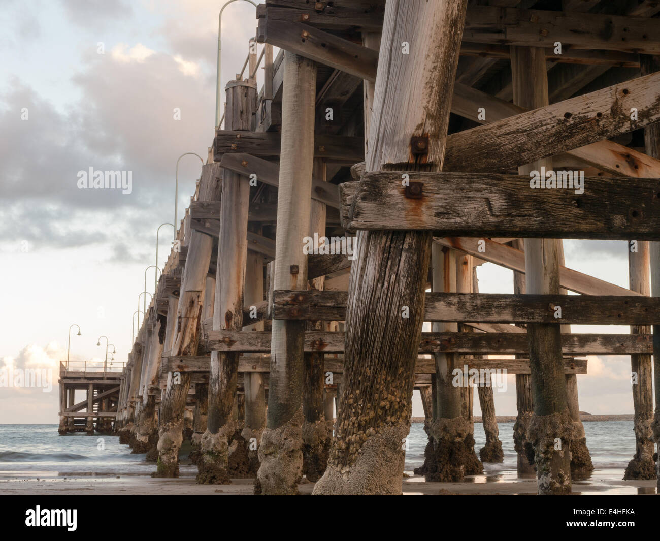 Ponte di legno che si estende verso l'oceano Foto Stock