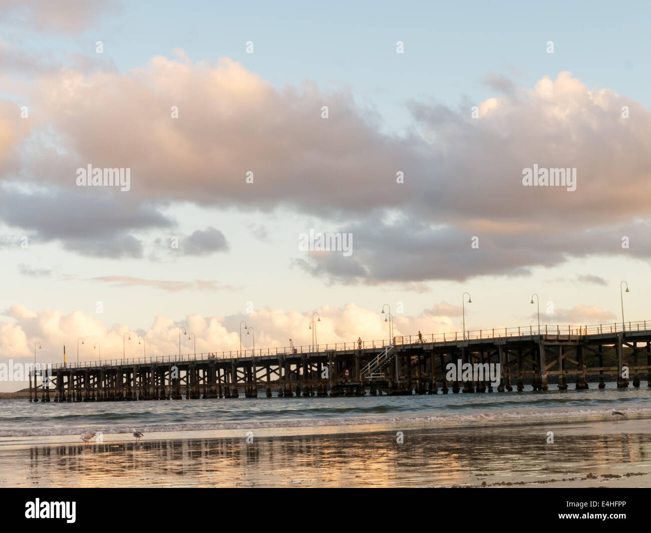 Ponte di legno che si estende verso l'oceano Foto Stock