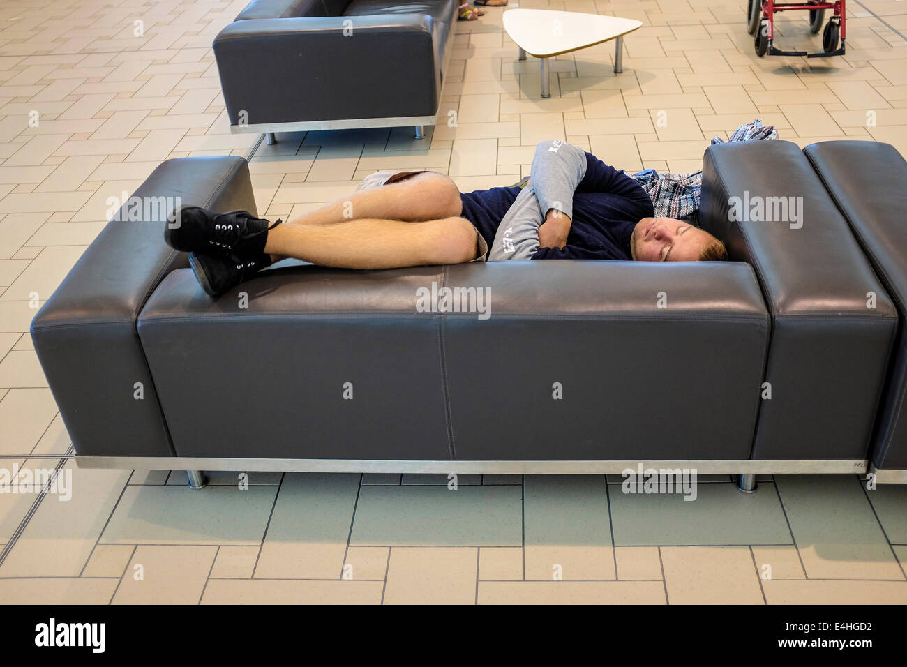 Un viaggiatore le catture fino a un po' di sonno in attesa per il volo presso l'Aeroporto Internazionale di Brisbane Foto Stock
