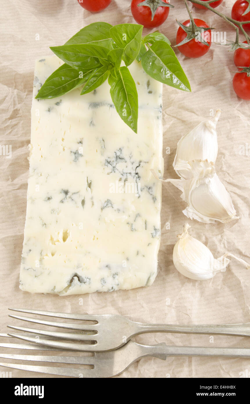 Formaggio Gorgonzola con cherry pomodoro aglio e basilico su della carta da cucina Foto Stock