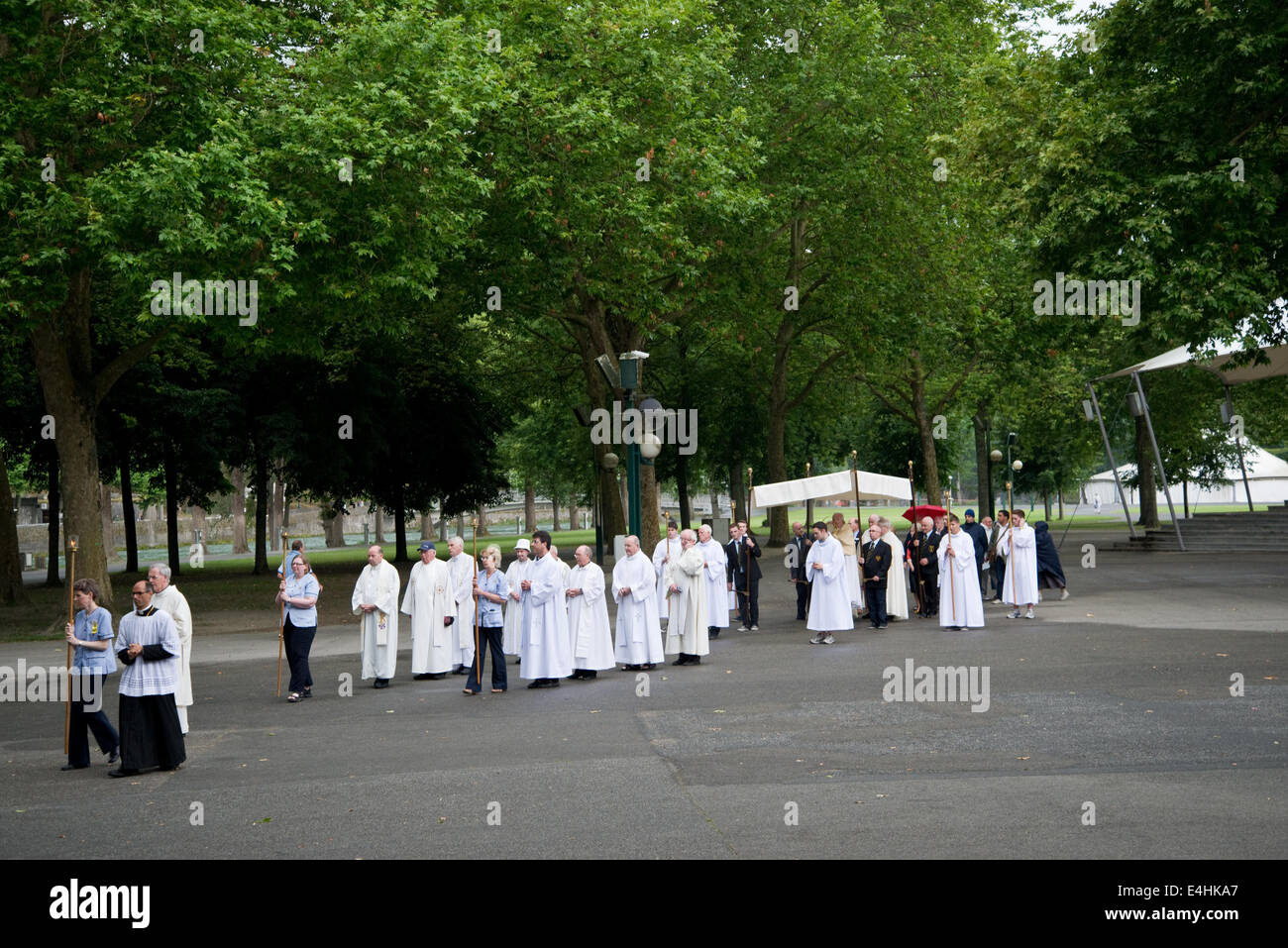 Le persone sono in preghiera a Lourdes facendo una processione di adorazione eucaristica Foto Stock