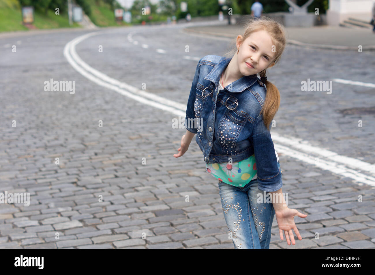 Divertente di moda bimba bionda indossando trendy camicia denim e jeans blu  mentre posa come un modello superiore all'esterno, su una strada di  ciottoli Foto stock - Alamy