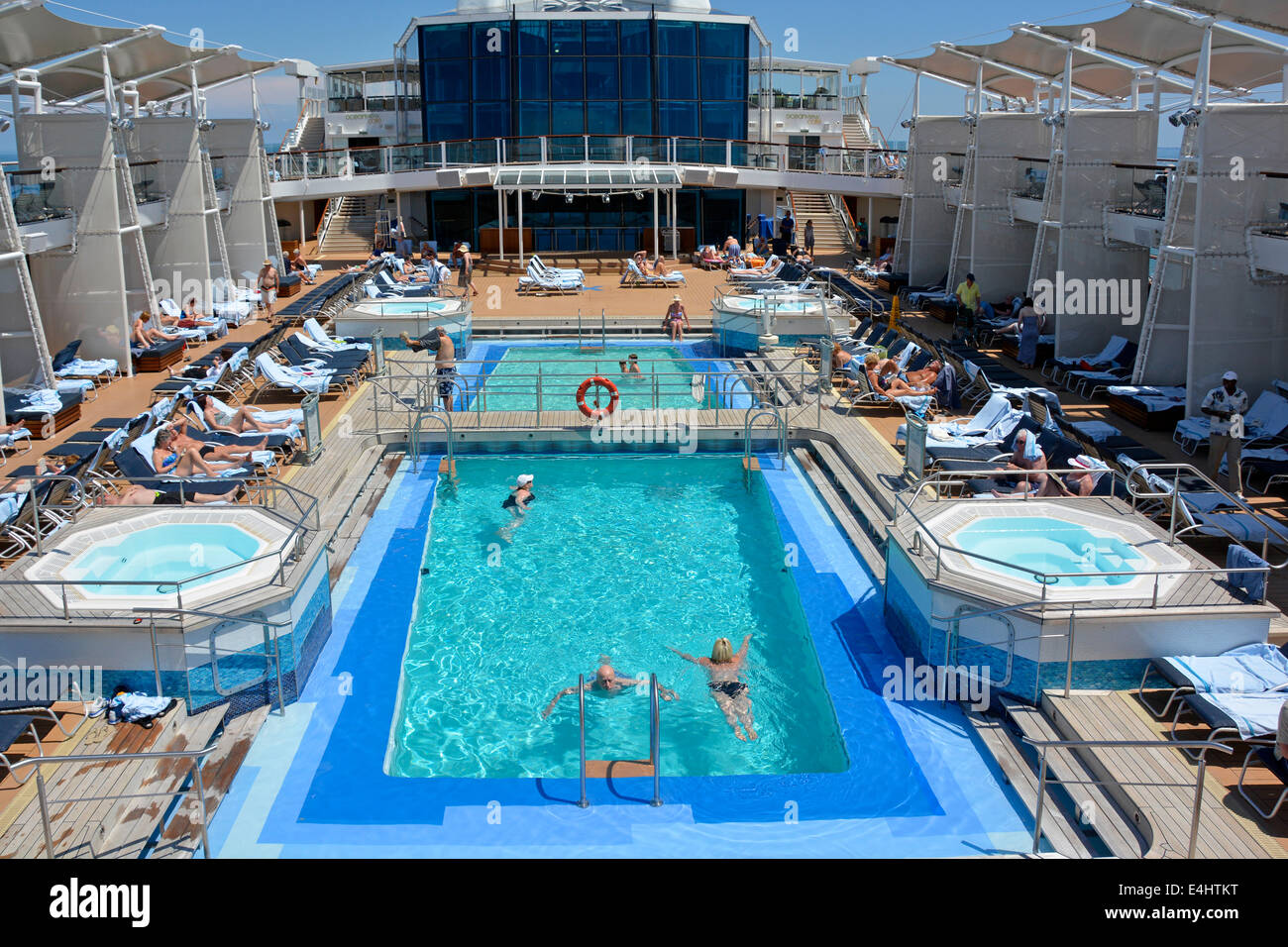 Persone in ocean liner cruise ship nuoto in piscina e relax sulle sedie a sdraio per prendere il sole mare Adriatico al largo della costa Italia Europa Foto Stock