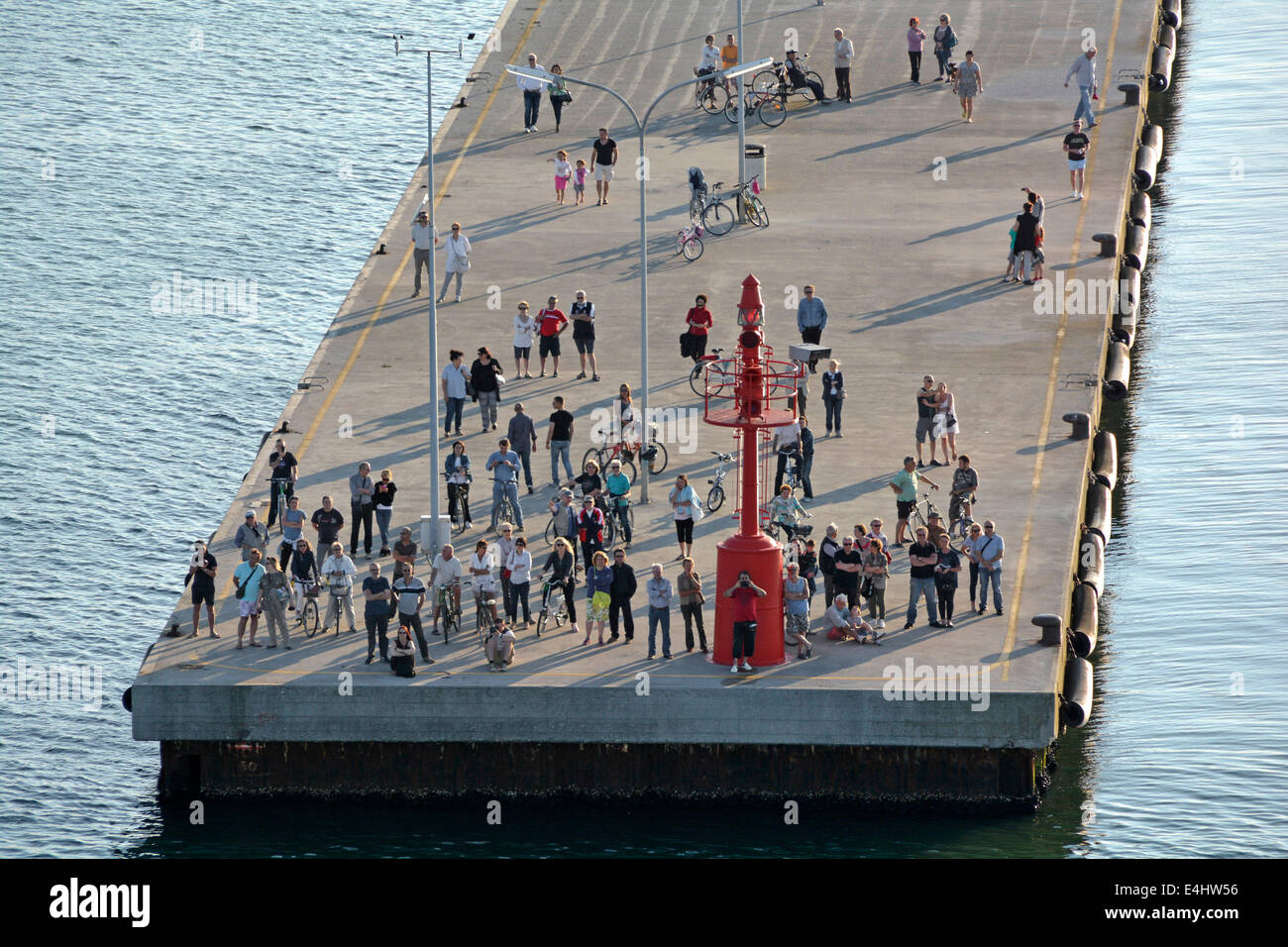 Le persone si radunano alla fine di Ravenna Marina Jetty per assistere alla partenza di un liner di grandi dimensioni in partenza Porto Corsini cruise terminal Foto Stock