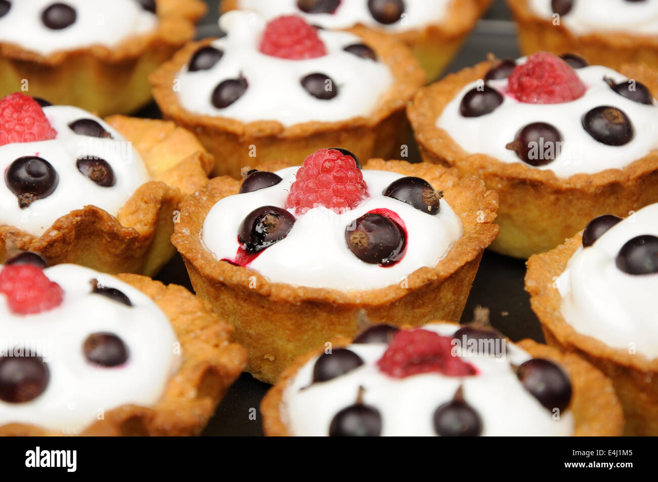 Cestini al forno con crema, ribes ant lampone sulla sommità. Potrebbe bu usata come sfondo Foto Stock