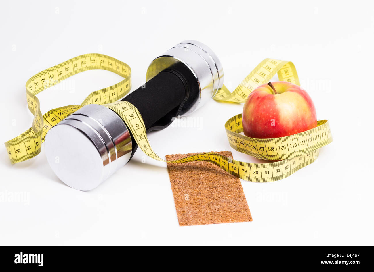 L'immagine mostra un barbell una misura di nastro e una fresca apple Foto Stock