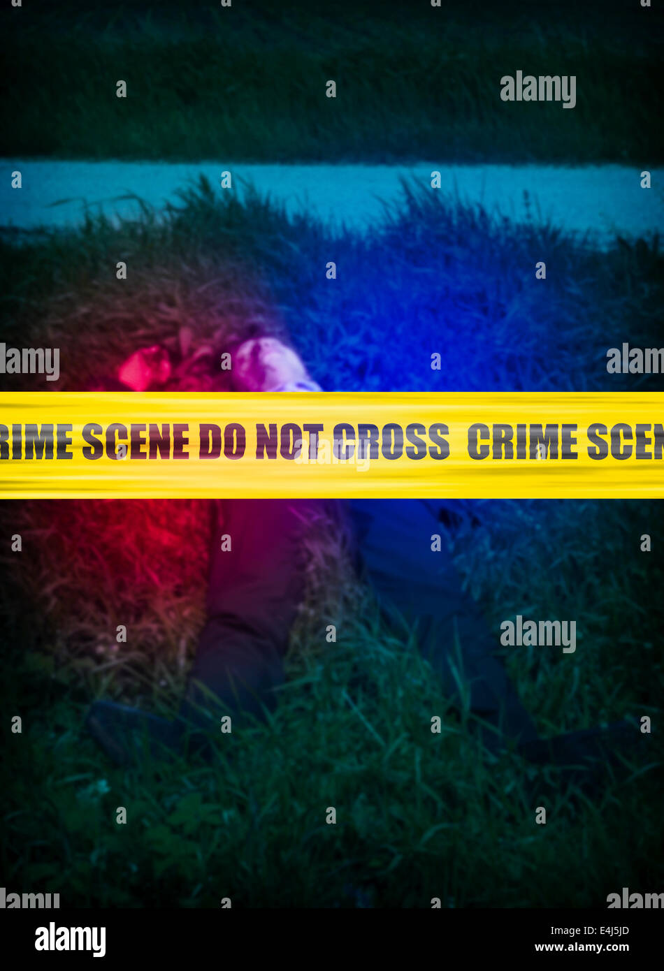Il giallo della scena del crimine cordon nastro sopra un corpo sfocate di un uomo in erba, persona non identificabili. Foto Stock