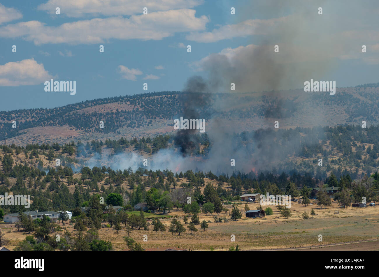 MADRAS, OREGON, Aprile 12th, 2014. Un wildfire erutta fiamme in prossimità di abitazioni e annessi appena fuori la città di Madras, Oregon nel centro di Oregon. Foto Stock